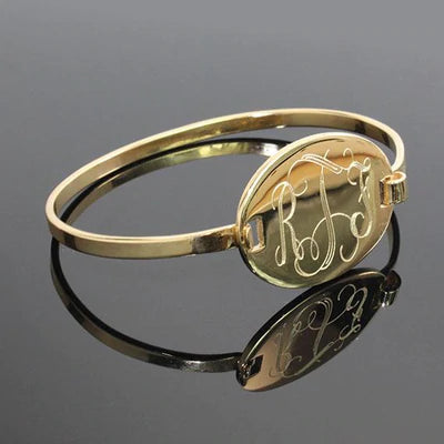 German Silver bracelet features an engraved 0.9" (24 mm) oval disk. Shown in gold plated with interlocking fort.